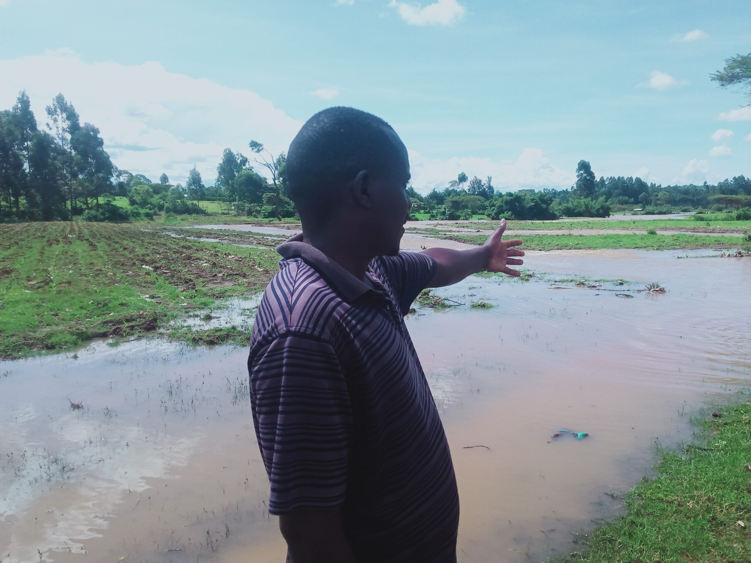CAPTION: Farmer pointing at his farmland swept by floods in Kipkenyo. PHOTO/Kipngeno Mutai